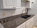 A kitchen sink with granite countertops and stainless steel faucet under white cabinetry at 155 N Pearl Lake Cswy # 200, Altamonte Springs, FL 32714
