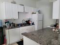 White kitchen with granite countertops and appliances at 155 N Pearl Lake Cswy # 200, Altamonte Springs, FL 32714