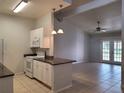 A living room and kitchen area with tile flooring, ceiling fan, and pendant lights at 155 N Pearl Lake Cswy # 200, Altamonte Springs, FL 32714