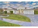 Two-story house with gray siding, three-car garage, and a well-maintained lawn at 2423 Hyatt Creek Ln, Port Orange, FL 32128