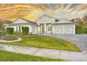 Stunning two-story home with gray siding, three-car garage, and beautifully landscaped yard at 2423 Hyatt Creek Ln, Port Orange, FL 32128