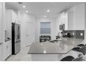 Modern kitchen with gray countertops, white cabinets, and stainless steel appliances at 3087 Camden Way, Davenport, FL 33837