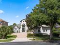 Charming two-story home with a tile roof, lush landscaping, and large trees at 408 Chelsea Ave, Davenport, FL 33837