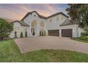 Lovely two-story home with a brick driveway and tile roof, shown at dusk at 408 Chelsea Ave, Davenport, FL 33837