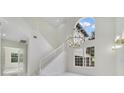 Bright foyer features high ceilings, statement chandelier, and staircase at 408 Chelsea Ave, Davenport, FL 33837