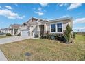Two-story house with a two-car garage and landscaped yard at 6922 Audobon Osprey Cv, Harmony, FL 34773