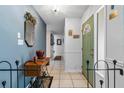 Hallway with tiled floor, antique furniture, and green door at 8134 Hook Cir, Orlando, FL 32836