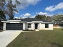 Charming one-story home featuring a dark gray two-car garage and well-maintained lawn at 102 Colomba Rd, Debary, FL 32713