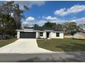 Charming one-story home featuring a dark gray two-car garage and well-maintained lawn at 102 Colomba Rd, Debary, FL 32713