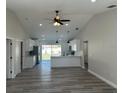 Open-concept living space with sleek wood floors, vaulted ceiling, and an adjacent modern kitchen at 102 Colomba Rd, Debary, FL 32713