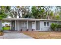 Gray single story house with carport and well-manicured lawn at 1110 Oak Dr, Leesburg, FL 34748