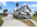 Gray house with white accents, a wooden door, and a detached garage at 119 Leon Ave, Deland, FL 32720