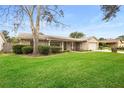 Tan house with stone accents, a large tree, and a well-manicured lawn at 1266 Juliana Pl, Orlando, FL 32807