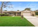 Tan house with stone accents, landscaped lawn, and a two-car garage at 1266 Juliana Pl, Orlando, FL 32807