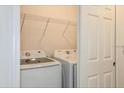 Bright laundry room with washer and dryer, and built-in shelving at 267 Bottle Brush Dr, Haines City, FL 33844