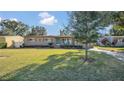 Tan house with teal door, paved walkway and lawn at 3020 Nancy St, Orlando, FL 32806