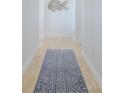 Clean hallway with blue patterned rug and white walls at 5501 S Atlantic Ave # 4150, New Smyrna Beach, FL 32169