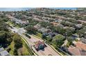 An aerial view of a charming neighborhood featuring lush landscaping and a lake in the background at 9132 Via Bella Notte, Orlando, FL 32836