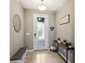 Bright entryway with tiled floor, bench, and decorative mirror at 1040 Sadie Ridge Rd, Clermont, FL 34715