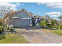 Gray house with stone accents and a paved driveway at 1040 Sadie Ridge Rd, Clermont, FL 34715