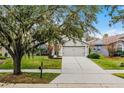 One-story house with gray siding, attached garage, and mature landscaping at 1105 Harbor Hill St, Winter Garden, FL 34787