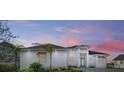 White two-story house with palm trees and a sunset at 118 River Ln, Ormond Beach, FL 32176