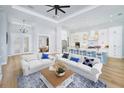 Open living space with white sofas and a kitchen island at 118 River Ln, Ormond Beach, FL 32176