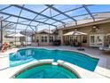 Screened in pool and spa with outdoor seating and dining area at 13132 Coldwater Loop, Clermont, FL 34711