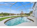 Kidney-shaped pool with screened enclosure overlooking a lake at 13656 Crystal River Dr, Orlando, FL 32828