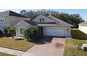 Single-story home with a light beige exterior and a two-car garage at 2408 Addison Creek Dr, Kissimmee, FL 34758