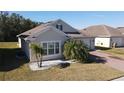 Tan one-story house with a white garage door and palm trees in front at 2408 Addison Creek Dr, Kissimmee, FL 34758