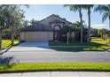 Tan one story house with a brown door and two car garage at 2612 Keswick Ct, Kissimmee, FL 34744