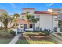 Front view of townhome with walkway, landscaping, and a two-car garage at 4818 Marks Ter # 385 B2, Orlando, FL 32811