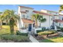 Townhome with a tiled roof, palm trees, and a well-manicured lawn at 4818 Marks Ter # 385 B2, Orlando, FL 32811