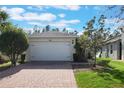 Two-car garage with white door and paver driveway at 560 Presido Park Pl, Kissimmee, FL 34759