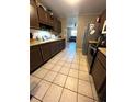 Eat-in kitchen with dark wood cabinets and tiled floor at 6133 Olympic Ct, Orlando, FL 32808