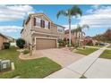 Two-story house with brown exterior, brick driveway, and landscaping at 648 Cortona Dr, Orlando, FL 32828