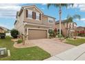 Two-story house with brown exterior, brick driveway, and landscaping at 648 Cortona Dr, Orlando, FL 32828