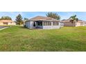 Rear view of house showing a screened porch and grassy backyard at 707 Terranova Ave, Winter Haven, FL 33884