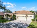 Exterior view of a house with a three-car garage and a paved driveway at 8231 Lynch Dr, Orlando, FL 32835