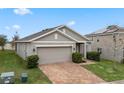 Tan one story house with a two car garage and brick driveway at 9653 Early Loop, Groveland, FL 34736