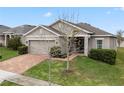 One-story house with a two-car garage and a tree in the front yard at 9653 Early Loop, Groveland, FL 34736