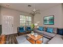 Virtually staged living room with gray sofa, teal accent pillows, and wood coffee table at 12557 Langstaff Dr, Windermere, FL 34786