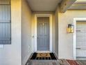 Gray front door with a welcome mat and gray shutters at 165 Williamson Dr, Davenport, FL 33897