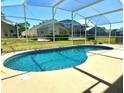 Kidney shaped swimming pool with a screened enclosure at 1708 Clubhouse Cv, Haines City, FL 33844