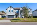 Two-story house with gray exterior, landscaping, and a two-car garage at 1713 Fullers Oak Loop, Winter Garden, FL 34787