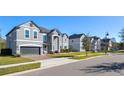 Houses on a street with lawns and sidewalks; one is gray and two stories at 1713 Fullers Oak Loop, Winter Garden, FL 34787