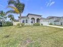 Landscaped front yard with palm tree and gray house at 1870 Dumbleton Pl, St Cloud, FL 34771