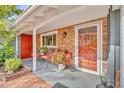 Brick front porch with red door and two comfy chairs at 1871 Linden Rd, Winter Park, FL 32792