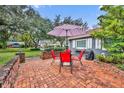 Brick patio with red chairs and umbrella, great for outdoor dining at 1871 Linden Rd, Winter Park, FL 32792